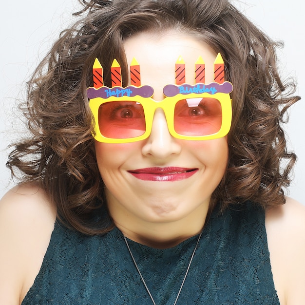 Jeune femme heureuse avec de grandes lunettes de soleil orange, prête pour la fête