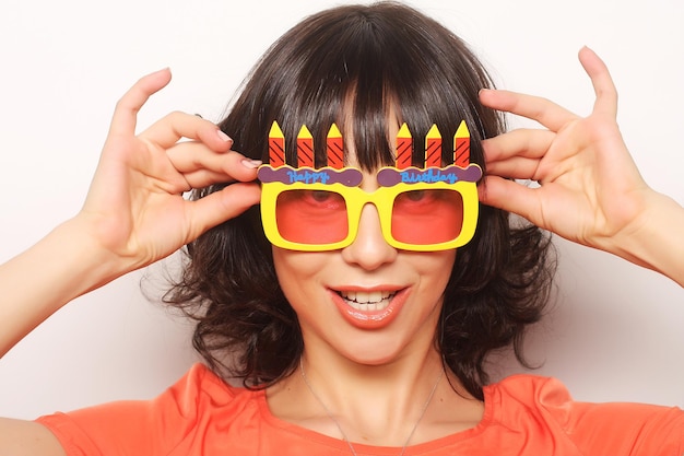 Jeune femme heureuse avec de grandes lunettes de soleil orange, prête pour la fête