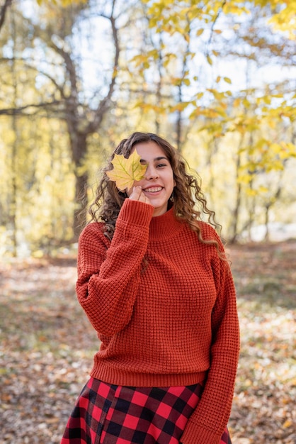 Jeune femme heureuse marchant dans la forêt d'automne