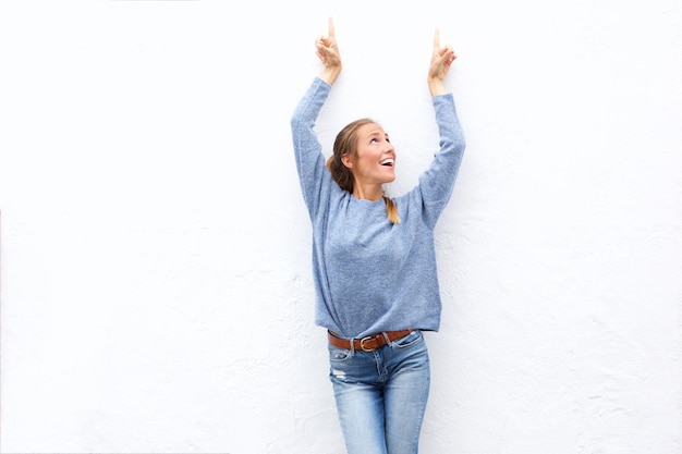 Une jeune femme heureuse montrant du doigt