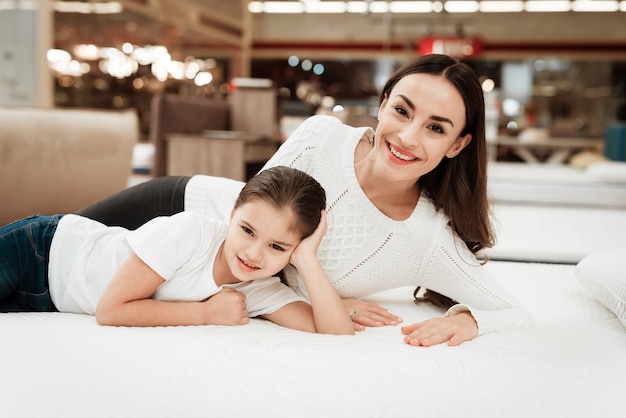 Jeune femme heureuse et petite fille sur un matelas