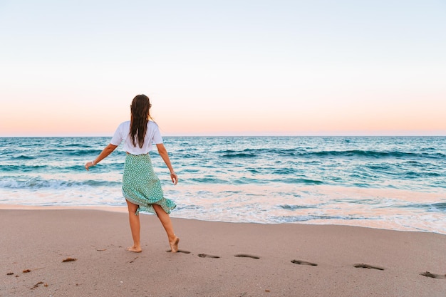 Jeune femme heureuse sur la plage profite de ses vacances d'été La fille est heureuse et calme pendant son séjour sur la plage