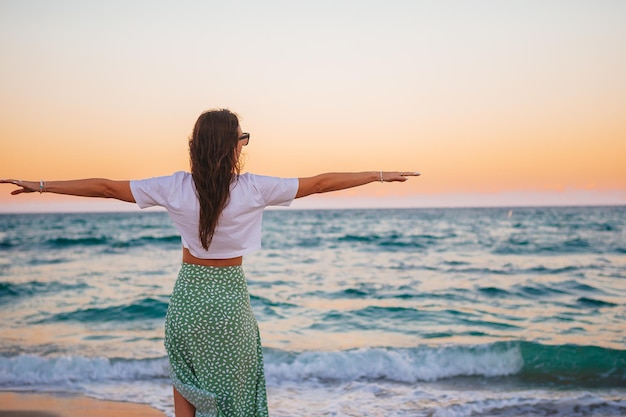 Jeune femme heureuse sur la plage profite de ses vacances d'été La fille est heureuse et calme pendant son séjour sur la plage