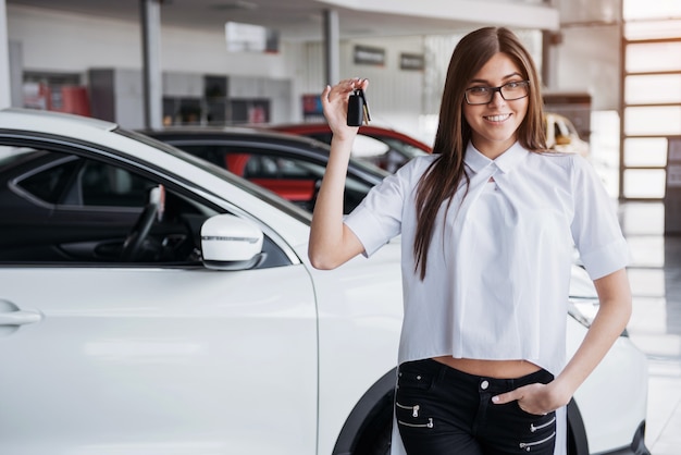 Jeune femme heureuse près de la voiture avec les clés en main