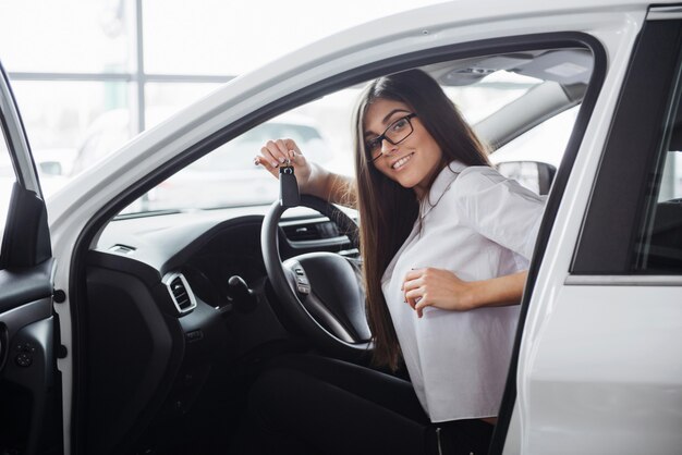 Jeune femme heureuse près de la voiture avec les clés en main