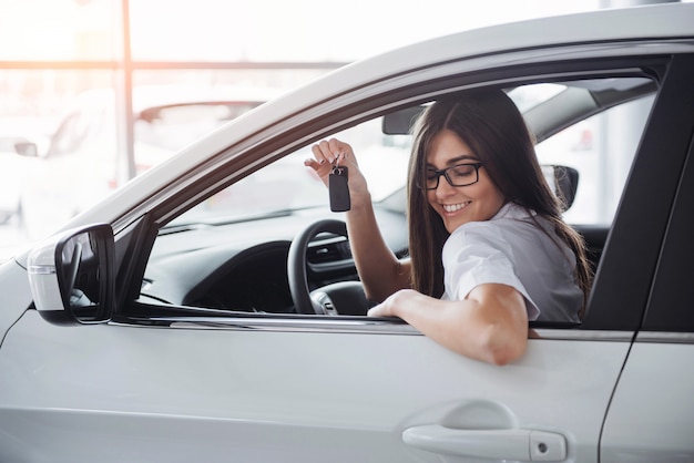 Jeune femme heureuse près de la voiture avec les clés en main