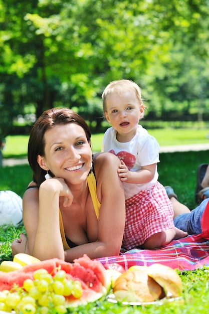 une jeune femme heureuse et son bébé s'amusent en jouant dans un magnifique parc lumineux en été