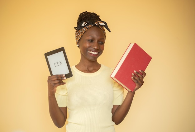 jeune femme heureuse avec son livre imprimé tout en tenant un livre électronique à batterie vide.