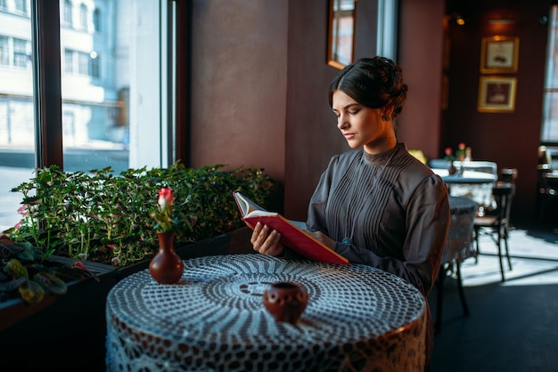 Jeune femme heureuse souriante au café