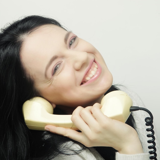 Jeune femme heureuse avec téléphone vintage