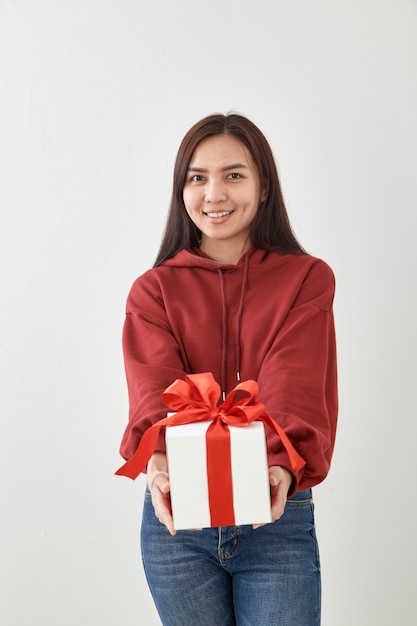 Jeune femme heureuse tenir sa boîte cadeau en mains