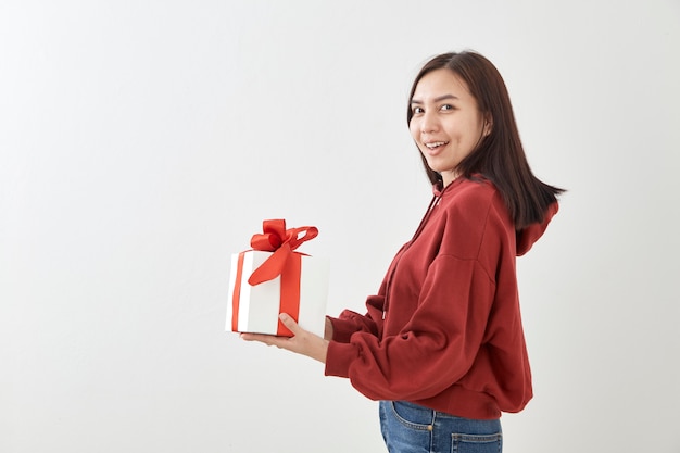 Jeune femme heureuse tenir sa boîte cadeau en mains