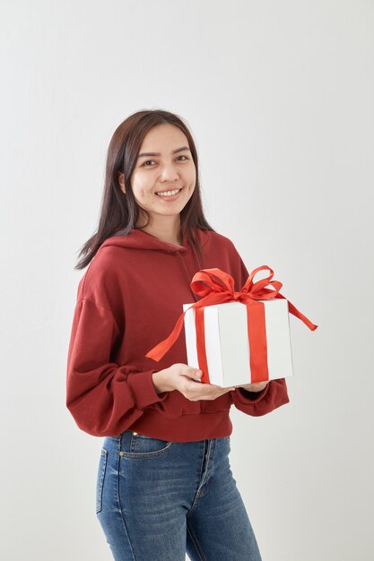 Jeune femme heureuse tenir sa boîte cadeau en mains