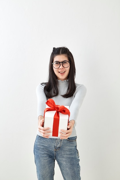 Jeune femme heureuse tenir sa boîte cadeau en mains