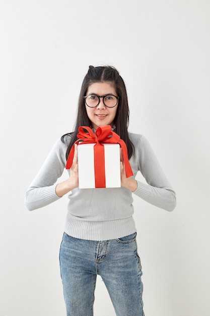 Jeune femme heureuse tenir sa boîte cadeau en mains