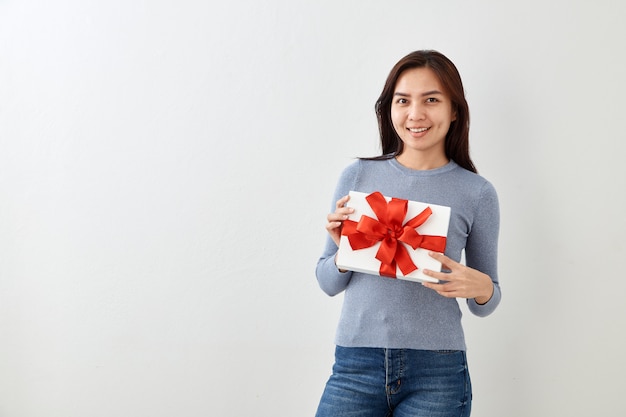 Jeune femme heureuse tenir sa boîte cadeau en mains