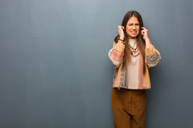 Jeune femme hippie couvrant les oreilles avec les mains