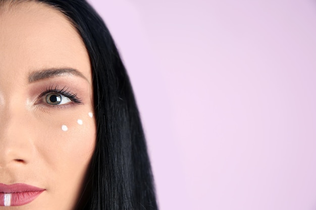 Jeune femme hippie avec maquillage bohème sur fond de couleur agrandi