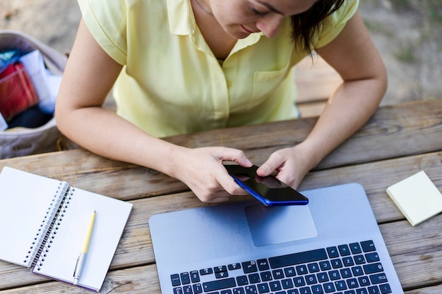 Photo jeune femme hipster tapant et s'amusant avec un smartphone interaction sociale sur les nouvelles tendances technologiques et la connexion internet dans le style de vie vintage de tous les jours utilisation d'appareils technologiques à l'extérieur