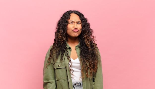 Photo jeune femme hispanique à l'air maladroit et drôle avec une expression stupide qui louche, plaisantant et s'amusant