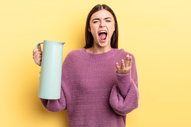 Jeune femme hispanique à la colère, agacée et frustrée. concept de thermos à café