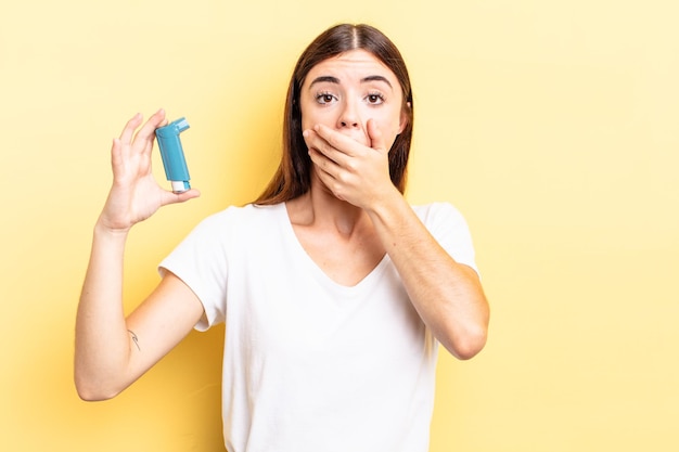 Jeune femme hispanique couvrant la bouche avec les mains avec un choc. concept d'asthme