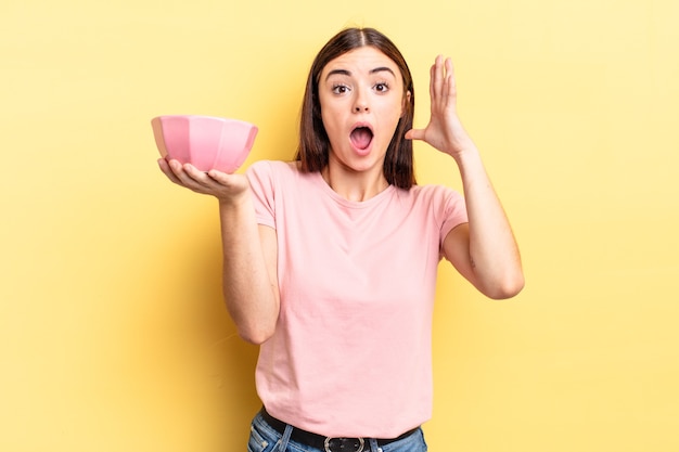 Jeune femme hispanique criant avec les mains en l'air. concept de bol vide