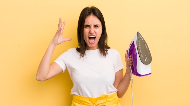 Jeune femme hispanique criant avec les mains en l'air concept de fer à repasser