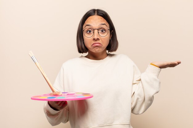 Photo jeune femme hispanique doutant ou pensant, se mordant la lèvre et se sentant en insécurité et nerveuse, à la recherche de copier l'espace sur le côté