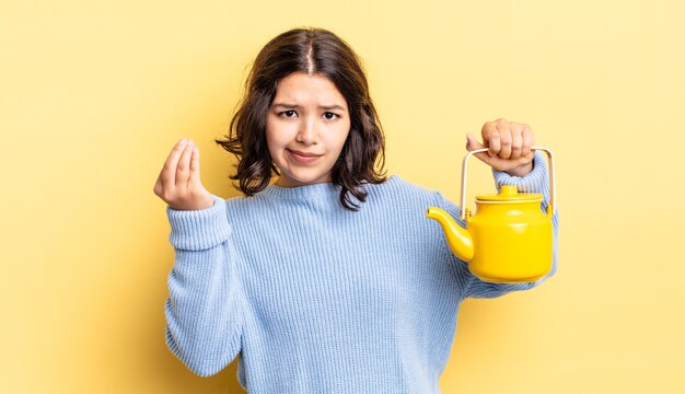 Jeune femme hispanique faisant un geste de capice ou d'argent, vous disant de payer. notion de théière