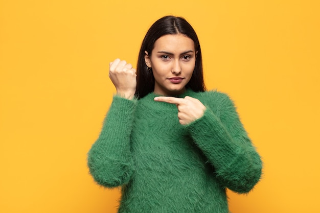 Jeune femme hispanique à l'impatience et en colère, pointant la montre, demandant la ponctualité, veut être à l'heure