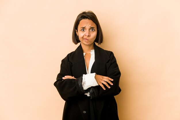 Jeune femme hispanique isolée souffle sur les joues, a une expression fatiguée. Concept d'expression faciale.