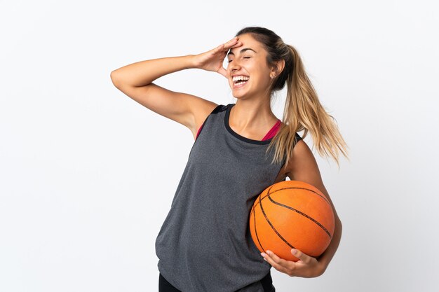 Jeune femme hispanique jouant au basket-ball sur un mur blanc isolé souriant beaucoup