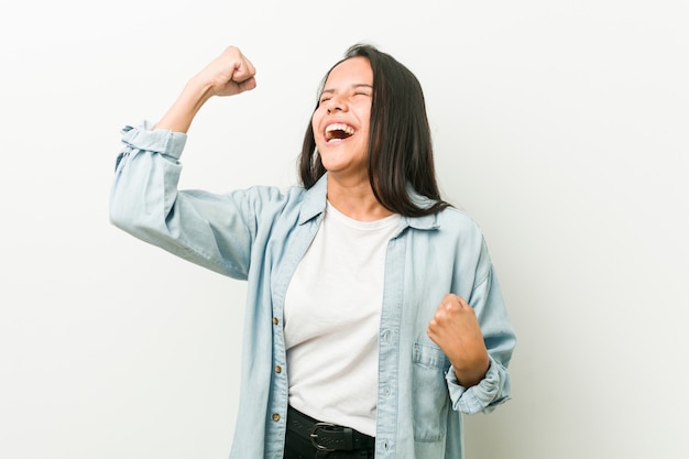 Jeune femme hispanique levant le poing après une victoire