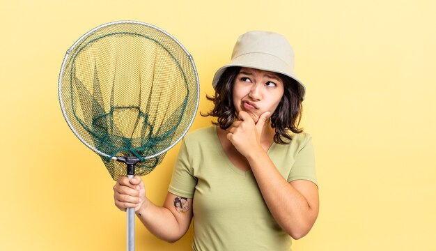 Jeune femme hispanique pensant, se sentant dubitative et confuse. concept de filet de pêcheur