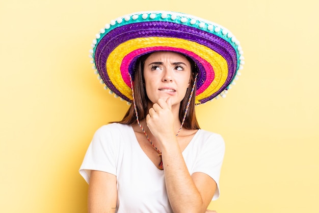 Jeune femme hispanique pensant se sentir douteuse et confuse concept de chapeau mexicain