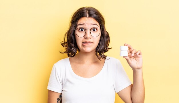 Jeune femme hispanique à la perplexité et confuse. concept de pilules contre la maladie