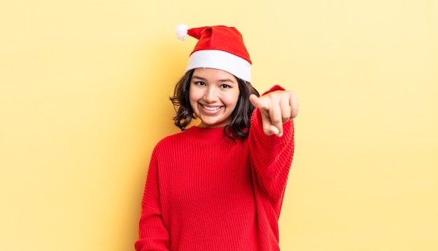 Jeune femme hispanique pointant vers la caméra en vous choisissant. notion de noël