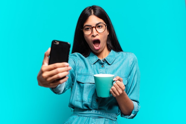 Jeune femme hispanique prenant un café