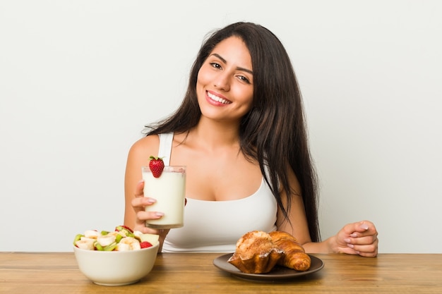 Jeune femme hispanique prenant son petit déjeuner sur la table