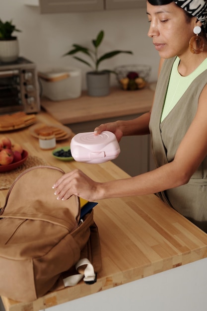 Une jeune femme hispanique prépare le déjeuner dans la cuisine.