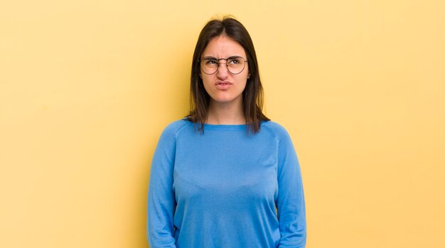 Jeune femme hispanique qui a l'air maladroite et drôle avec une expression loufoque idiote qui plaisante et s'amuse