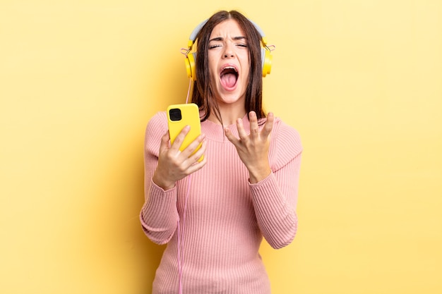 Jeune femme hispanique à la recherche désespérée, frustrée et stressée. casque et concept de téléphone