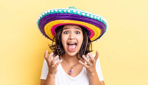 Jeune femme hispanique à la recherche désespérée, frustrée et stressée. concept de chapeau mexicain