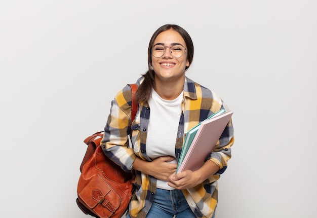 Jeune femme hispanique riant à haute voix à une blague hilarante, se sentant heureuse et joyeuse, s'amusant