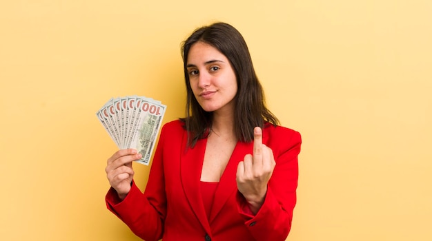 Jeune femme hispanique se sentant en colère agacée concept de billets en dollars rebelles et agressifs