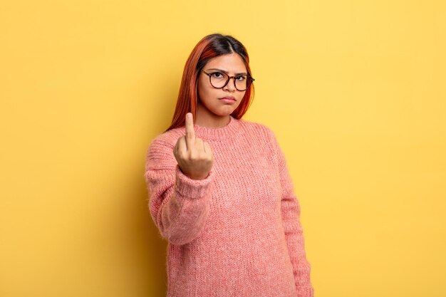 Jeune femme hispanique se sentant en colère agacée rebelle et agressive renversant le doigt du milieu ripostant