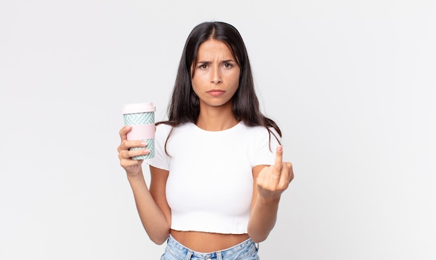 Jeune femme hispanique se sentant en colère, agacée, rebelle et agressive et tenant un récipient de café à emporter