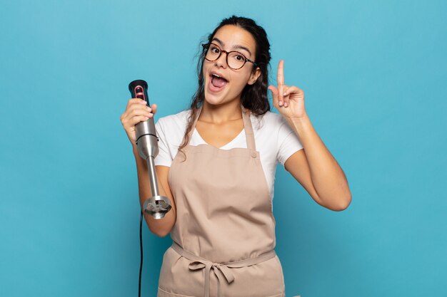 Jeune femme hispanique se sentant comme un génie heureux et excité après avoir réalisé une idée, levant joyeusement le doigt, eureka!