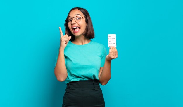 Jeune femme hispanique se sentant comme un génie heureux et excité après avoir réalisé une idée, levant joyeusement le doigt, eurêka !